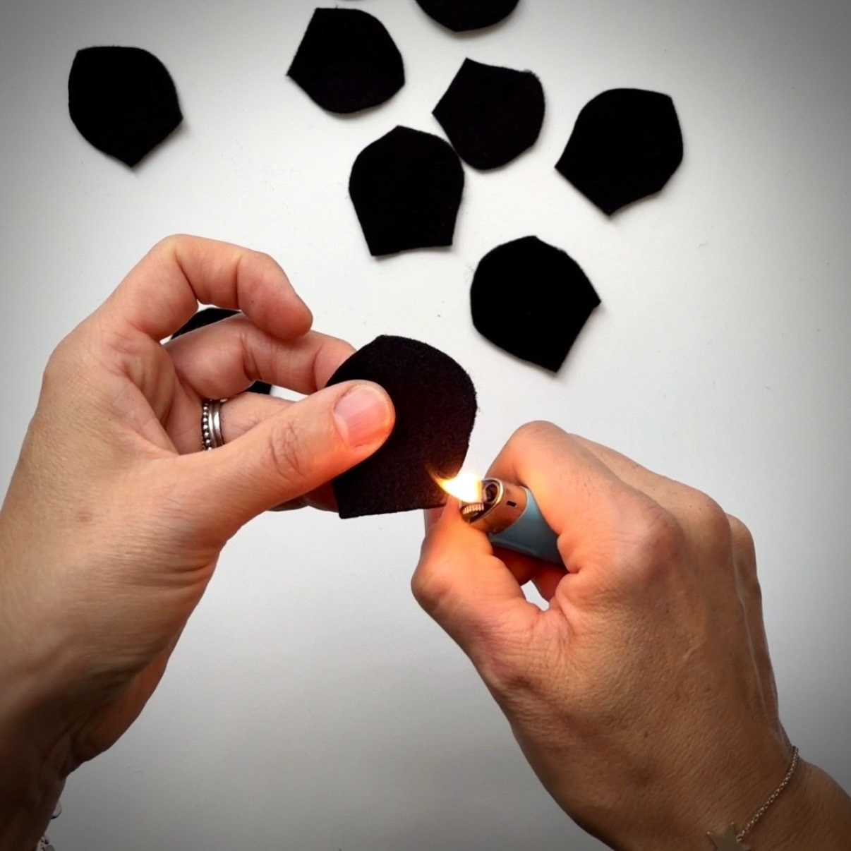 Pass the flame of a lighter over the edge of a black felt petal