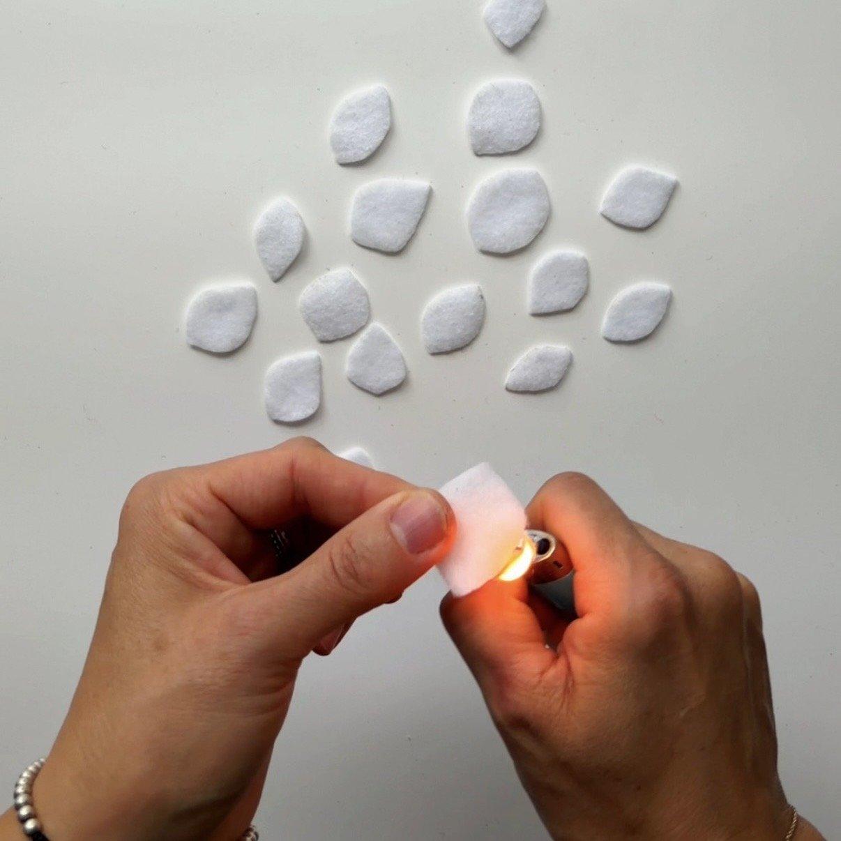 Pass the flame of a lighter over a white felt leaf